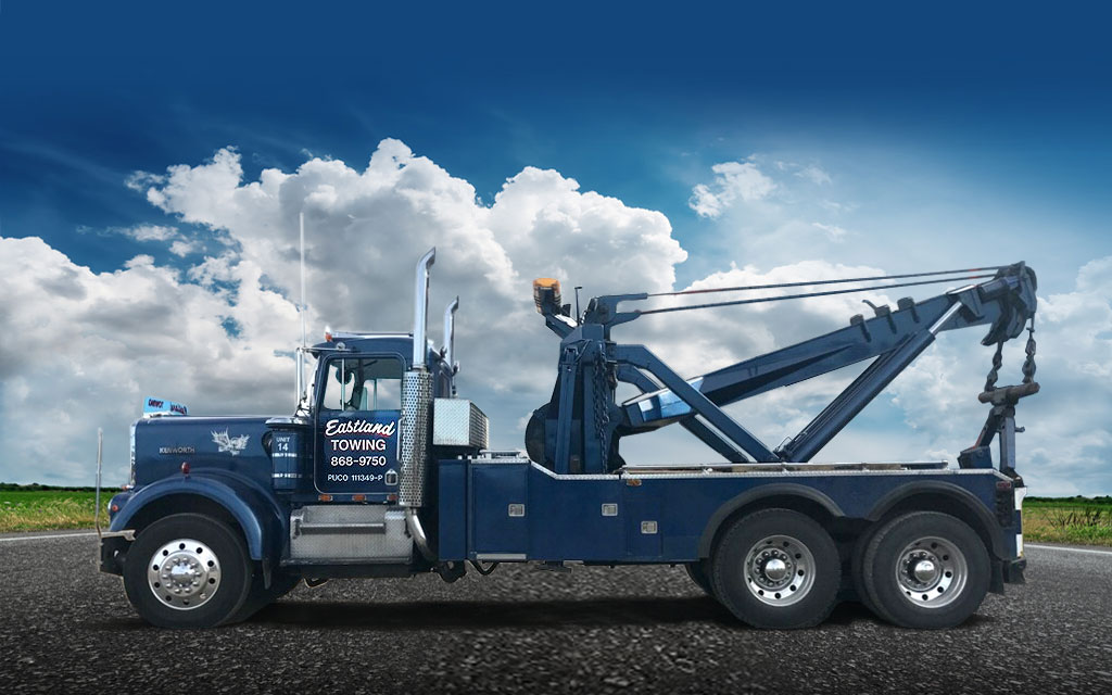 Eastland Towing blue 45 ton heavy-duty wrecker with a 45 ton boom that allows it to lift 90,000 lbs. Big Holmes winches for pulling heavy equipment and vehicles out of the mud.