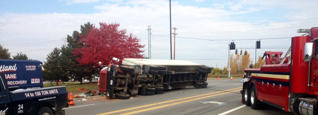 Eastland Towing heavy-duty wrecker and heavy recovery vehicles on the scene assisting an overturned tractor trailer.